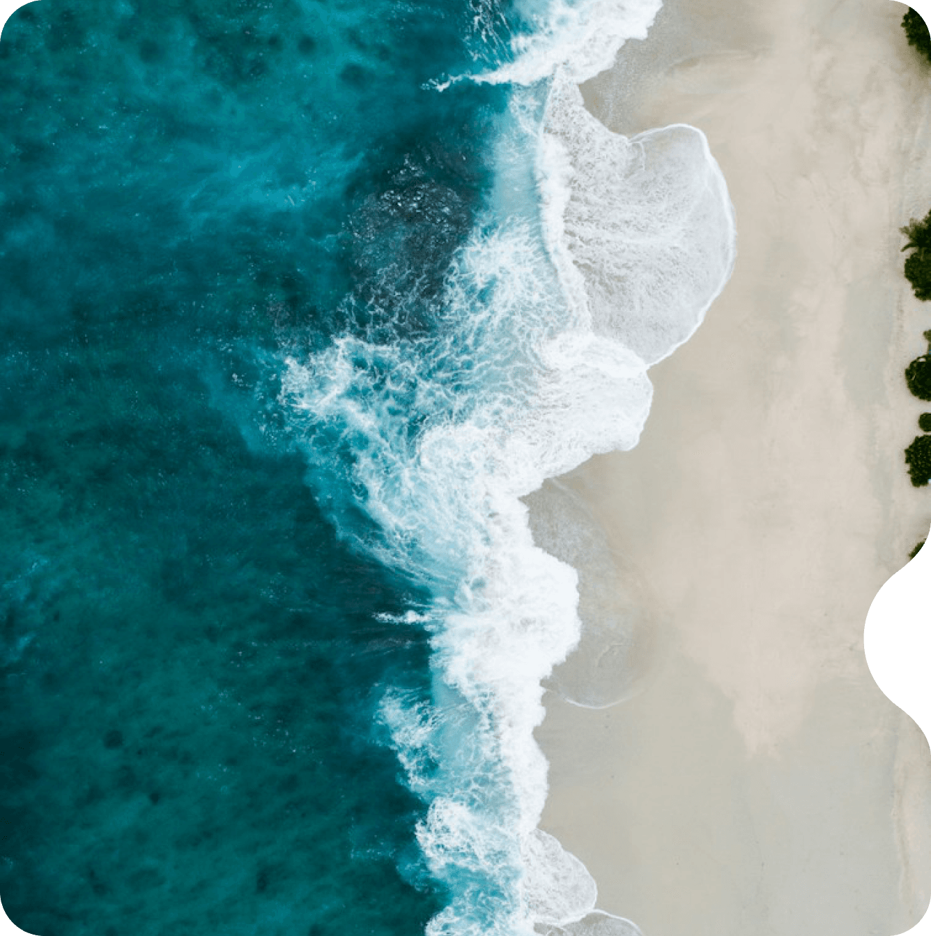 Aerial view of waves meeting a sandy beach